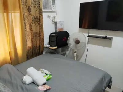 a hospital room with a bed with a tv and towels at Nicecondotel in Manila