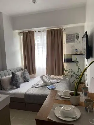 a bedroom with a bed and a table with plates on it at Buenbyahe Cozy Affordable Place at Urban Deca Tower along EDSA Shaw MRT walking distance in megamall in Manila