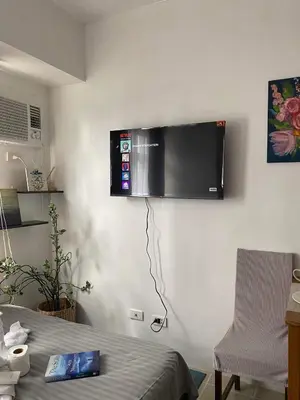 a room with a tv on a white wall at Buenbyahe Cozy Affordable Place at Urban Deca Tower along EDSA Shaw MRT walking distance in megamall in Manila
