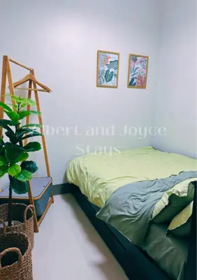 a bedroom with a bed and a ladder and a plant at Emma Mattress 1BR CONDO @ FAME (pool & city view) in Manila