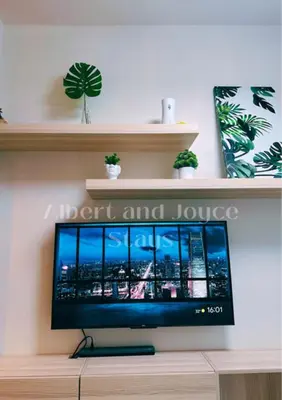 a flat screen tv sitting on top of a shelf at Emma Mattress 1BR CONDO @ FAME (pool & city view) in Manila