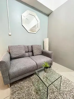 a living room with a couch and a glass table at Cozy Studio with SM Jazz Mall 