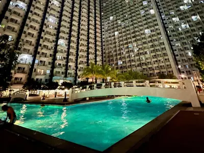 a large swimming pool in front of tall buildings at Cozy Studio with SM Jazz Mall 