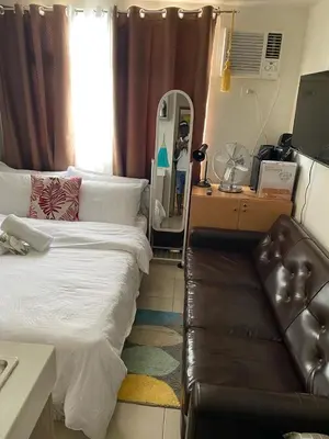a bedroom with a bed and a couch and a mirror at pierrecondotel in Manila