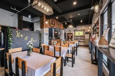 a dining room with tables and chairs and a chalkboard at Governor Forbes Inn - Manila City Center in Manila