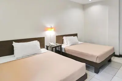 a hotel room with two beds and a phone at Governor Forbes Inn - Manila City Center in Manila
