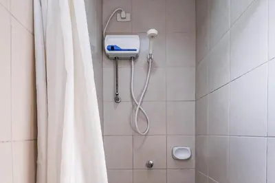 a shower with a shower curtain in a bathroom at Governor Forbes Inn - Manila City Center in Manila