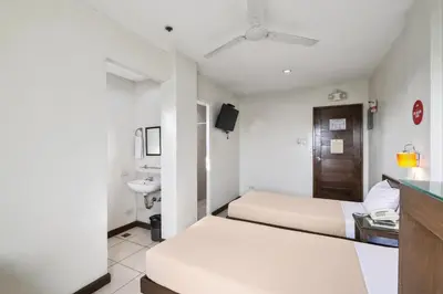 a hotel room with two beds and a sink at Governor Forbes Inn - Manila City Center in Manila