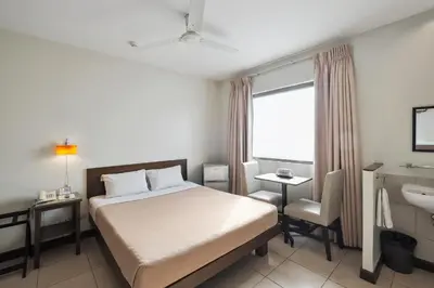 a hotel room with a bed and a sink at Governor Forbes Inn - Manila City Center in Manila