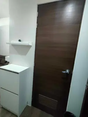 a brown door in a room with a shelf at 1 Bedroom with Balcony at Air Residences, Makati in Manila