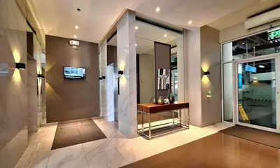 a lobby of a building with a table and a window at ELUDE Designer Suite Pasig - Prime Location in Manila
