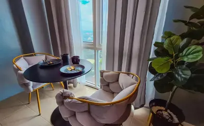 a table and chairs in a room with a window at ELUDE Designer Suite Pasig - Prime Location in Manila