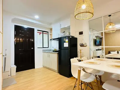 a kitchen and dining room with a black refrigerator at Raven's Nest Cozy Condo with Netflix Wi-fi in Imus in Imus