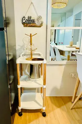 a food cart with a coffee sign on the wall at Raven's Nest Cozy Condo with Netflix Wi-fi in Imus in Imus