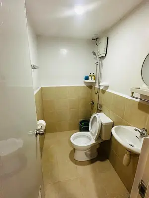 a bathroom with a toilet and a sink at Raven's Nest Cozy Condo with Netflix Wi-fi in Imus in Imus