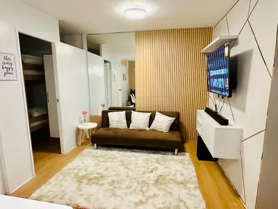 a living room with a couch and a tv at Raven's Nest Cozy Condo with Netflix Wi-fi in Imus in Imus