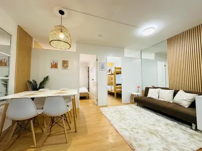 a living room with a table and a couch at Raven's Nest Cozy Condo with Netflix Wi-fi in Imus in Imus