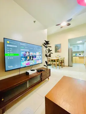 a living room with a large flat screen tv at 1 Queen Bed & 2 double beds at One Uptown Residences with XBOX and Netflix in Manila