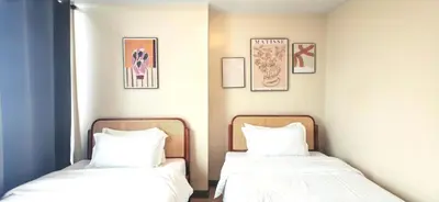 two beds sitting next to each other in a room at 1 Queen Bed & 2 double beds at One Uptown Residences with XBOX and Netflix in Manila