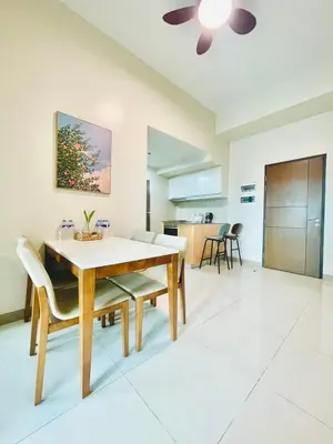 a dining room and kitchen with a table and chairs at 1 Queen Bed & 2 double beds at One Uptown Residences with XBOX and Netflix in Manila