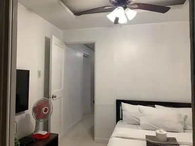a bedroom with a ceiling fan and a bed at Birch Tower a3 front of Robinson Mla FREEpool in Manila