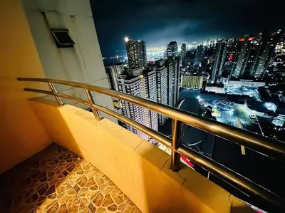 a balcony with a view of a city at night at Birch Tower a3 front of Robinson Mla FREEpool in Manila