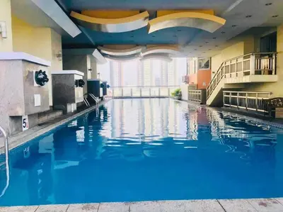 a large swimming pool with blue water in a building at Birch Tower a3 front of Robinson Mla FREEpool in Manila