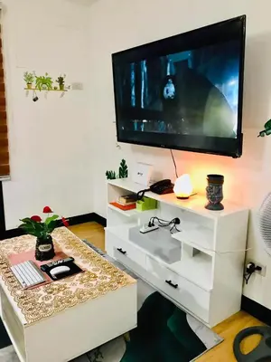 a living room with a television on a white entertainment center at The Escape Pad 7 in Manila