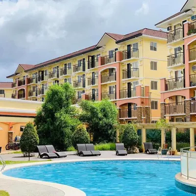 a hotel with a swimming pool in front of a building at The Escape Pad 7 in Manila