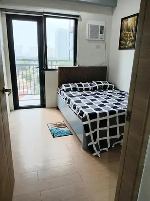a bedroom with a bed in a room with a window at Centro Tower - 2 Bedroom Fully Furnished in Manila
