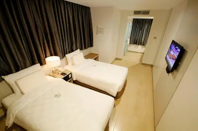 a hotel room with two beds and a flat screen tv at Go Hotels Ortigas Center in Manila