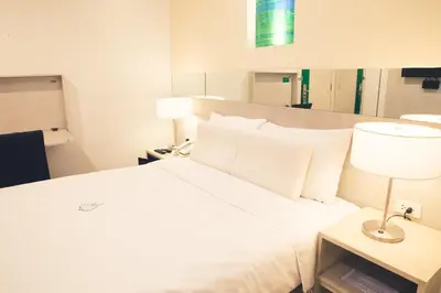 a bedroom with a large bed with white sheets and pillows at Go Hotels Ortigas Center in Manila