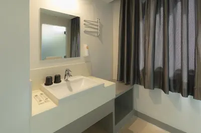 a bathroom with a white sink and a mirror at Go Hotels Ortigas Center in Manila