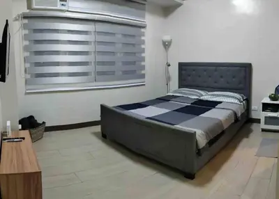 a bedroom with a large bed and a window at High speed internet - Cozy 1BR fully Furnished in Manila