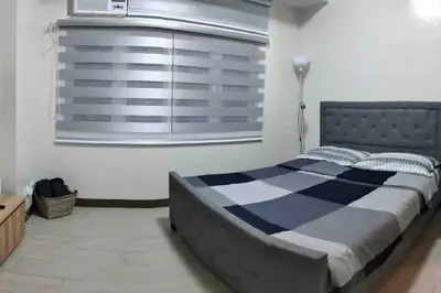 a bedroom with a large bed and a window at High speed internet - Cozy 1BR fully Furnished in Manila