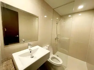 a bathroom with a sink and a toilet and a mirror at High speed internet - Cozy 1BR fully Furnished in Manila