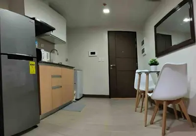 a kitchen with a refrigerator and a table and chairs at High speed internet - Cozy 1BR fully Furnished in Manila