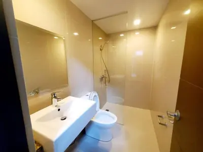 a bathroom with a sink and a toilet and a mirror at High speed internet - Cozy 1BR fully Furnished in Manila