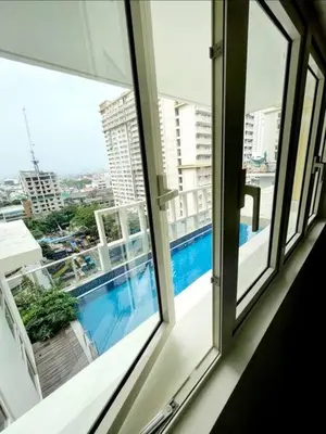 a view of a swimming pool from a window at High speed internet - Cozy 1BR fully Furnished in Manila