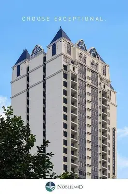 a tall white apartment building with a tree at Long term Rental of 2 BR Condo @Malate, Manila (opp Robinson Place Mall) in Manila