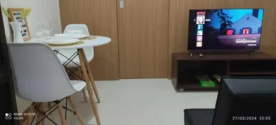 a small white table with two chairs and a television at Avery's Place at SMDC RED RES. in Manila
