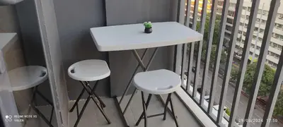 a white table and two stools on a balcony at Avery's Place at SMDC RED RES. in Manila