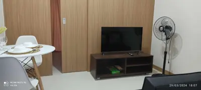 a living room with a tv and a table and a fan at Avery's Place at SMDC RED RES. in Manila
