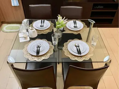 a glass table with plates on it with chairs at Modern Condo At Venice Residences Bgc #vlrb29k in Manila