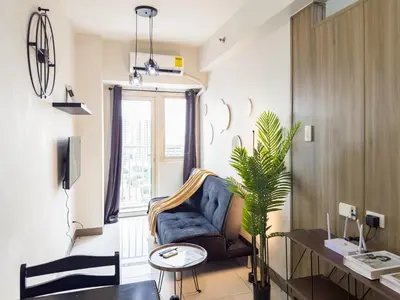 a living room with a couch and a table at GemstoneBR in SMDC Coast Residences in Manila