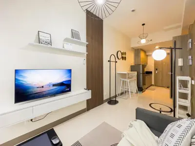 a living room with a flat screen tv on a wall at GemstoneBR in SMDC Coast Residences in Manila