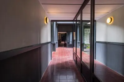 a hallway of a building with glass doors and a red tile floor at The Henry Hotel Manila in Manila