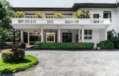 a white house with a balcony and a driveway at The Henry Hotel Manila in Manila