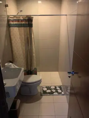 a small bathroom with a toilet and a shower at Grand Canal Penthouse! in Manila