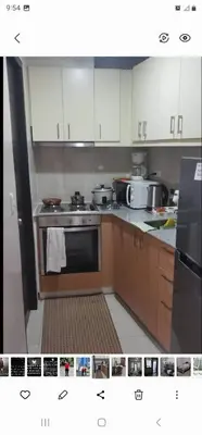 a kitchen with white cabinets and a stove top oven at Grand Canal Penthouse! in Manila